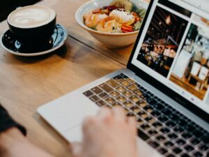A contemporary workspace with a laptop, coffee, and a bowl of soup, ideal for remote work settings.